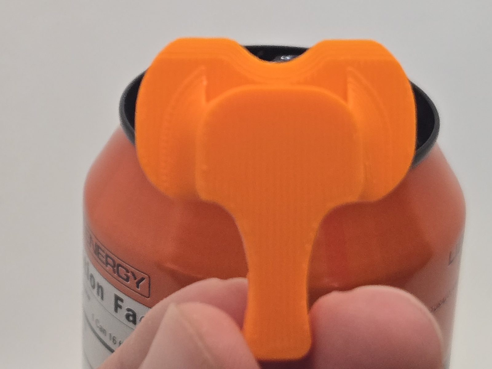 The Elephant Cover on a 12 oz can - a small orange can cover turned over the drink opening to keep bugs and dust out